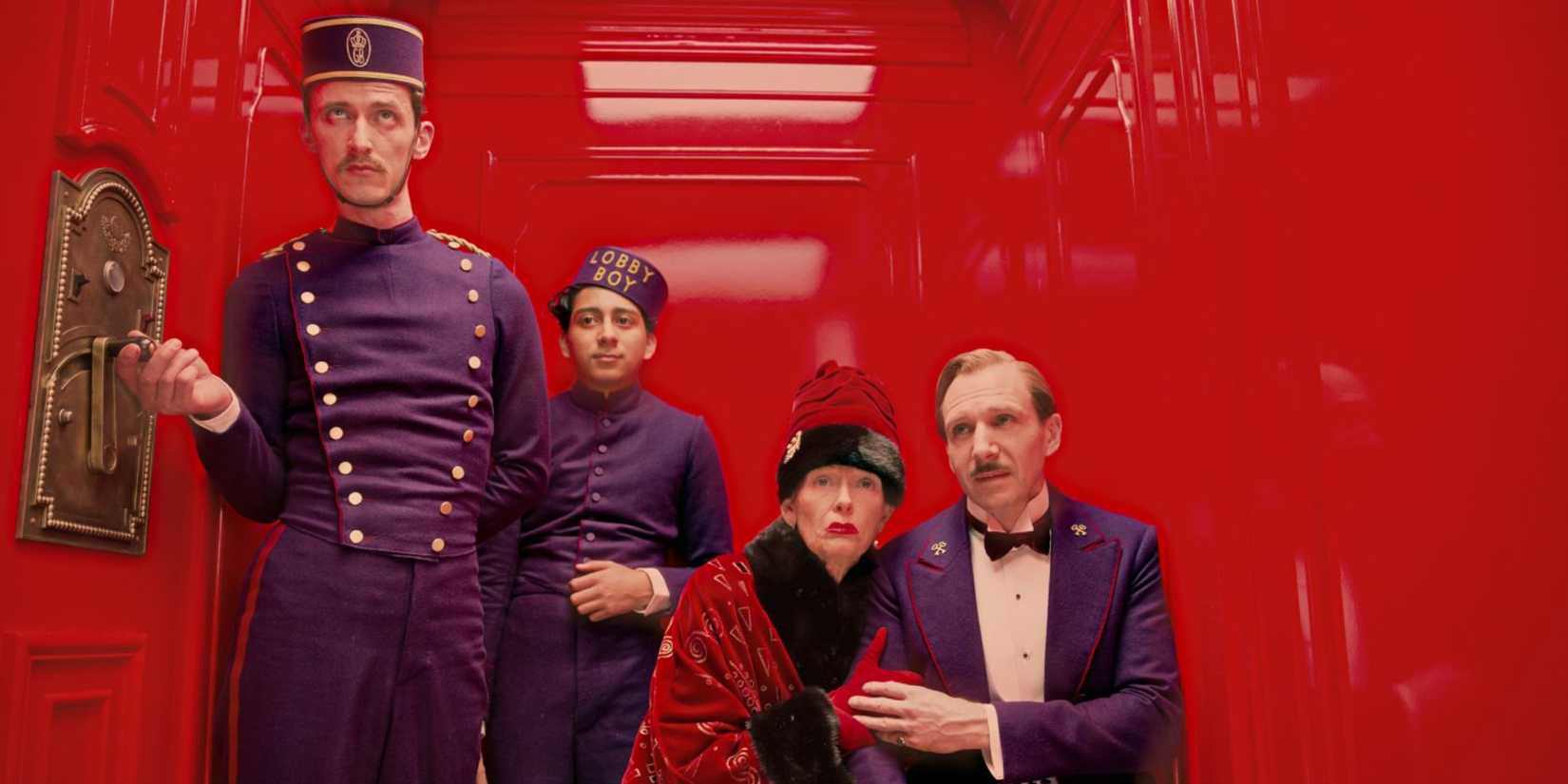 Several characters on a red elevator in The Grand Budapest Hotel.