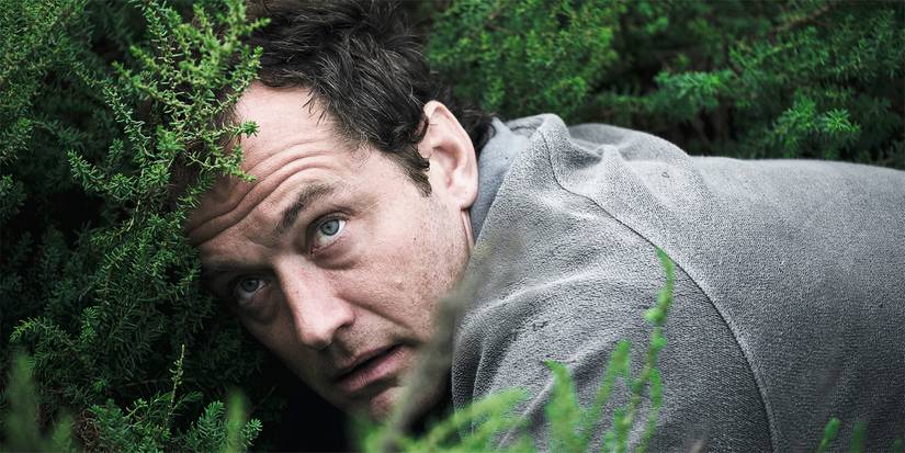 Jude Law as Sam hiding in a bush in 'The Third Day'.