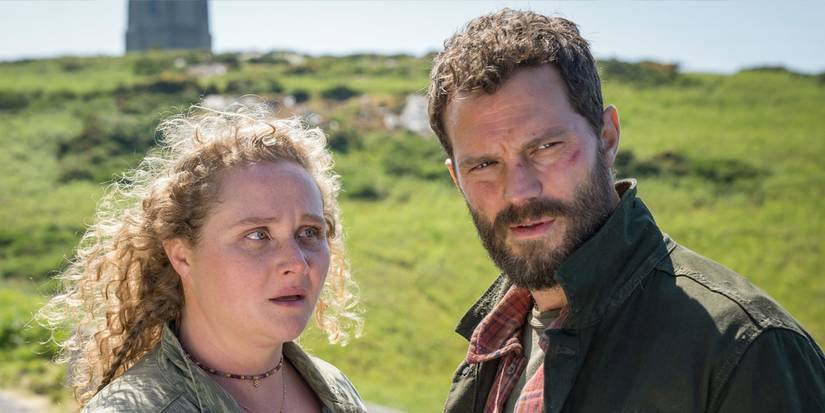 Danielle Macdonald and Jamie Dornan stand in a field while in Ireland in a scene from 'The Tourist' Season 2.