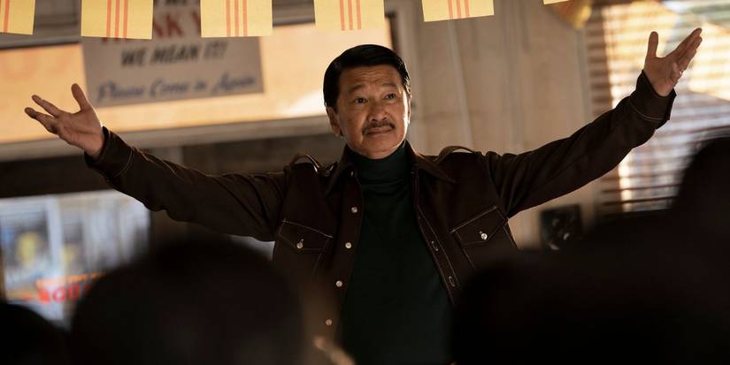 Toan Le as the General, raising his arms in the air, in The Sympathizer.