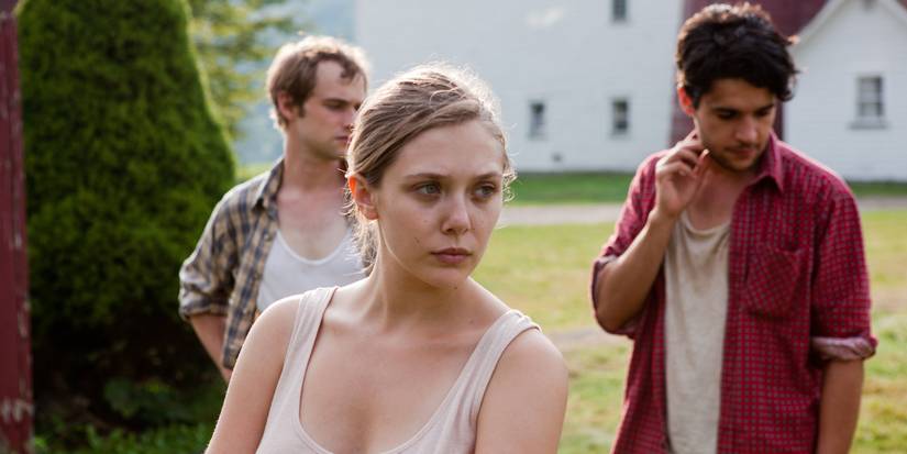  Martha looking to her left while two men stand behind her in Martha Marcy May Marlene