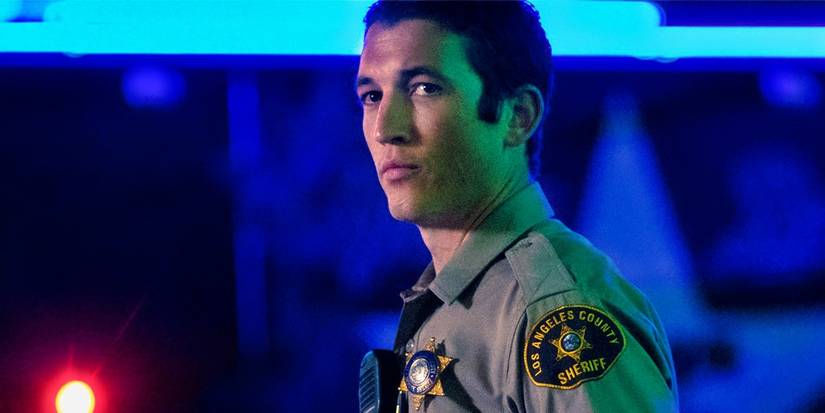Miles Teller in a sheriff's uniform looking to the side in Too Old to Die Young.