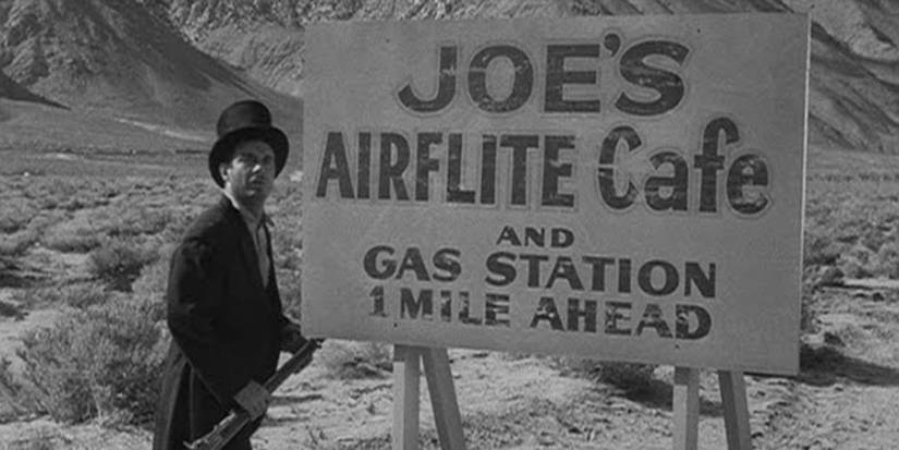 Chris Horn (Cliff Robertson) looks at a sign in 'The Twilight Zone' episode "A Hundred Yards Over the Rim"
