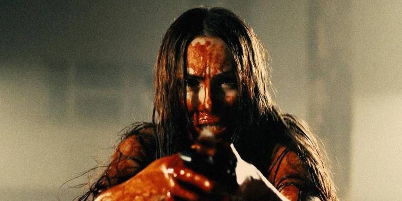 A bloodied woman holding a gun in Serbian Film