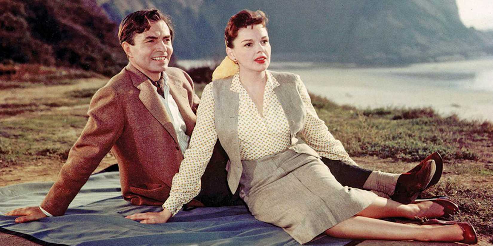 Normann and Esther laying on a blanket on the grass A Star is Born 1954