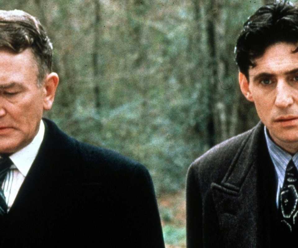Albert Finney standing next to Gabriel Byrne in the woods in Miller's Crossing (1990).
