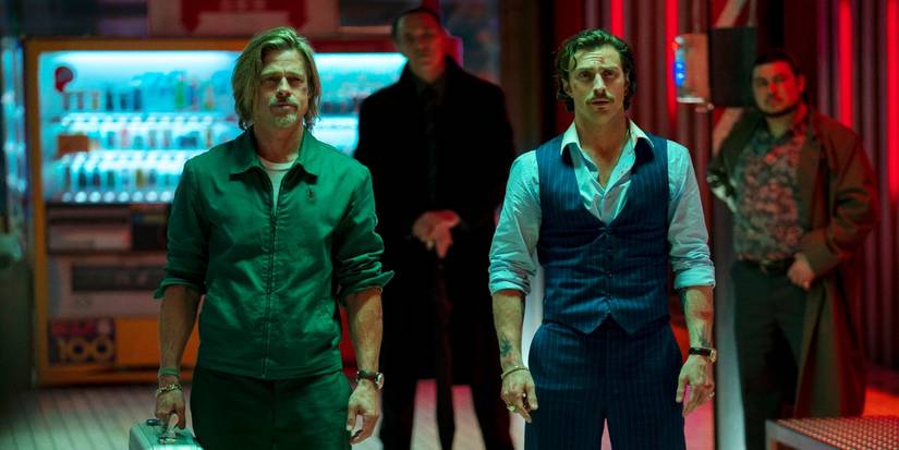 Aaron Taylor-Johnson and Brad Pitt stand side by side at a train station in Bullet Train 
