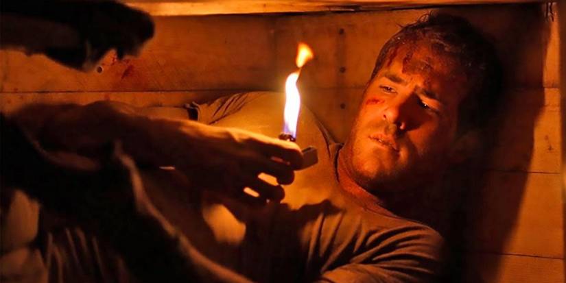Paul Conroy looking at the flames of a lighter in Buried