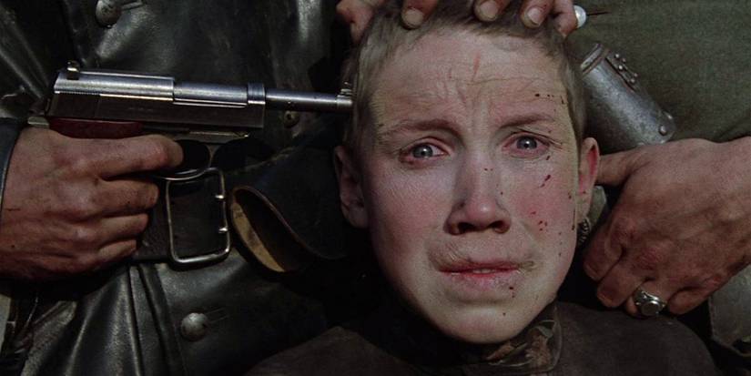 Flyora Gaishun, staring horrified at something offscreen while a gun is held to his temple in Come and See