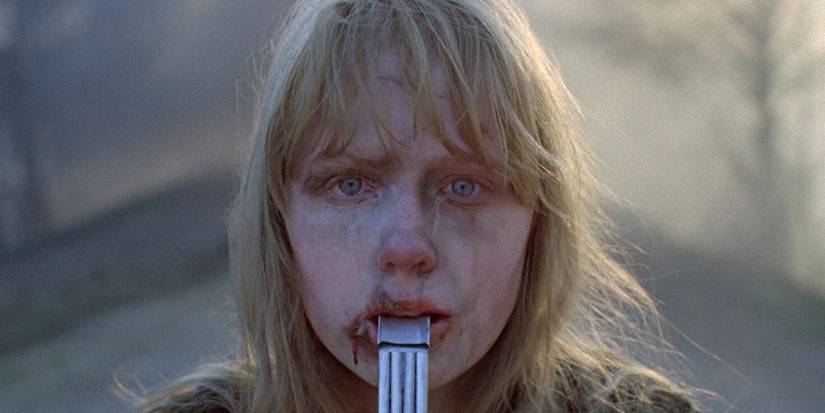 A girl crying and holding a whistle in her mouth at the end of Come and See