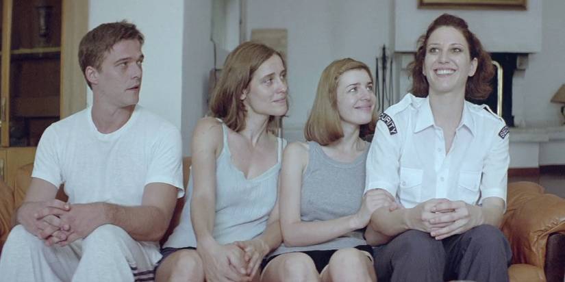 Christos Passalis, Angeliki Papoulia, Mary Tsoni, Anna Kalaitzidou sitting on the couch in Dogtooth