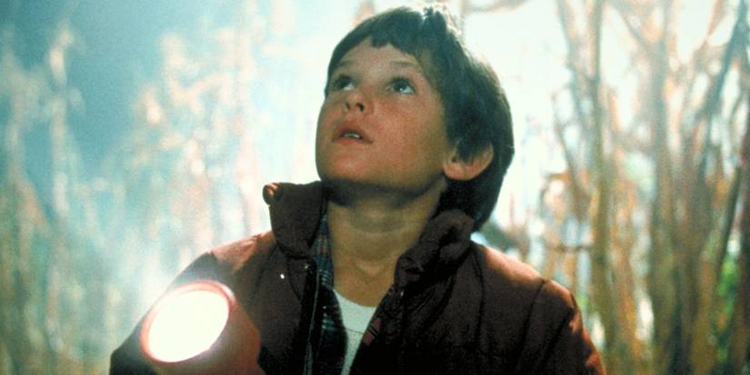 Henry Thomas in a cornfield holding a flashlight in E.T.