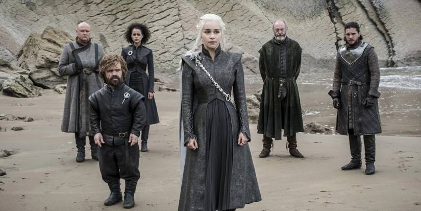 Daenerys Targaryen (Emilia Clarke) on a beach with her advisors and allies behind her in Game of Thrones.