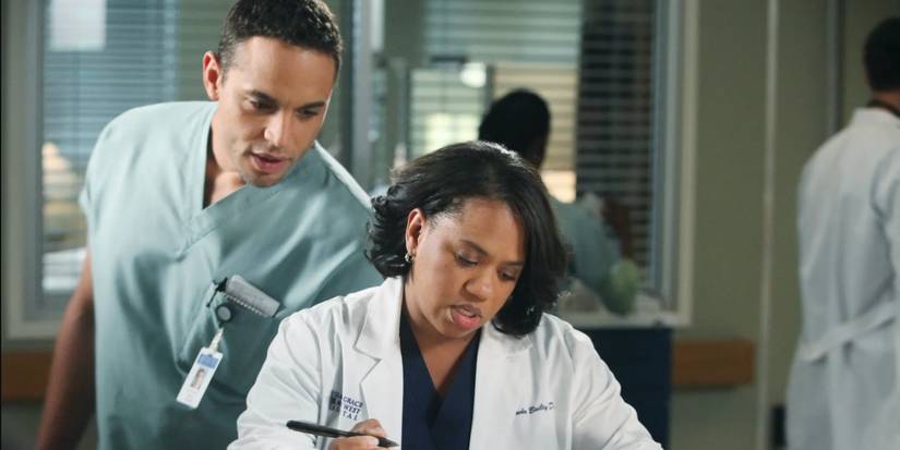 Dr. Miranda Bailey (Chandra Wilson) writes notes while Eli Lloyd (Daniel Sunjata) looks over her shoulder in Grey's Anatomy