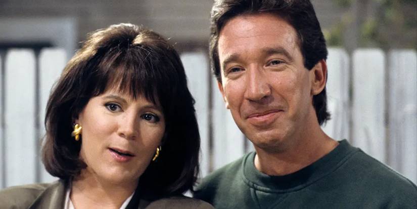 Patricia Richardson and Tim Allen standing in front of a white fence in Home Improvement.
