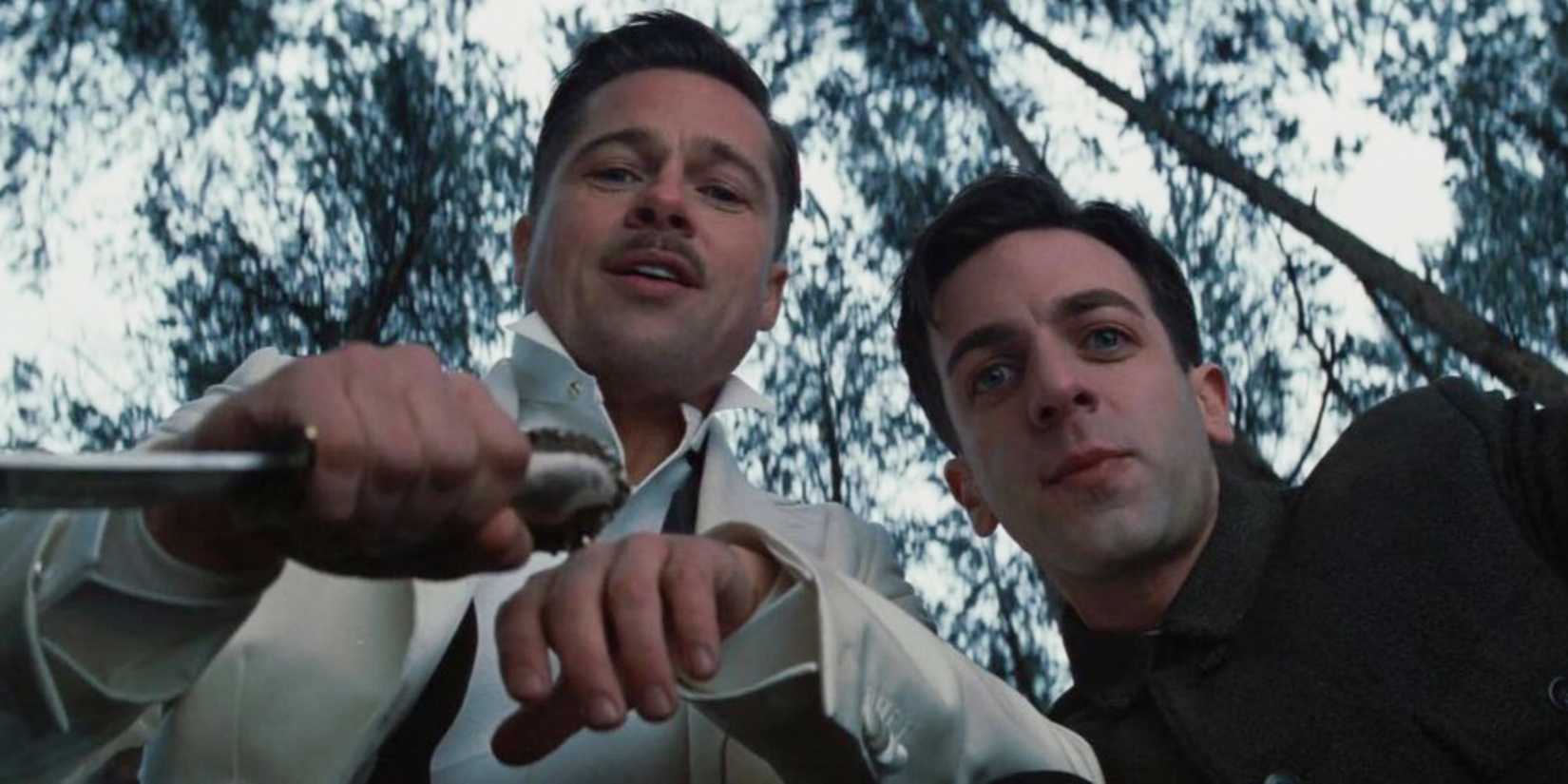 Aldo and Utivich in the woods, looking down at something and smiling in Inglourious Basterds