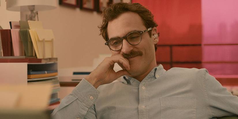 Joaquin Phoenix smiling with his hand to his face in Her