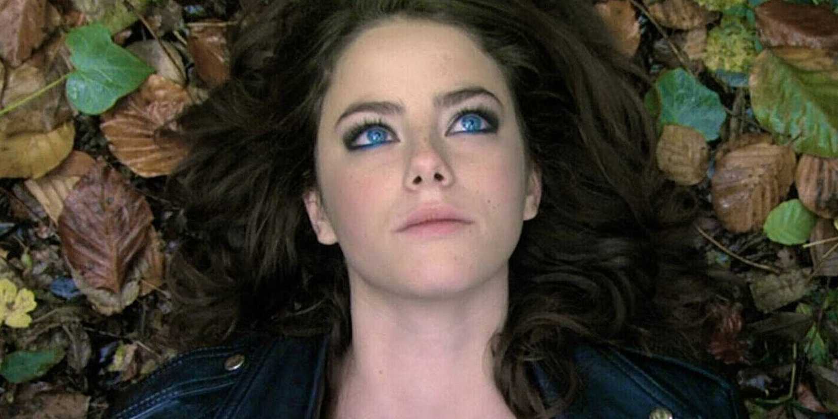 Kaya Scodelario in Skins lying on fallen leaves.