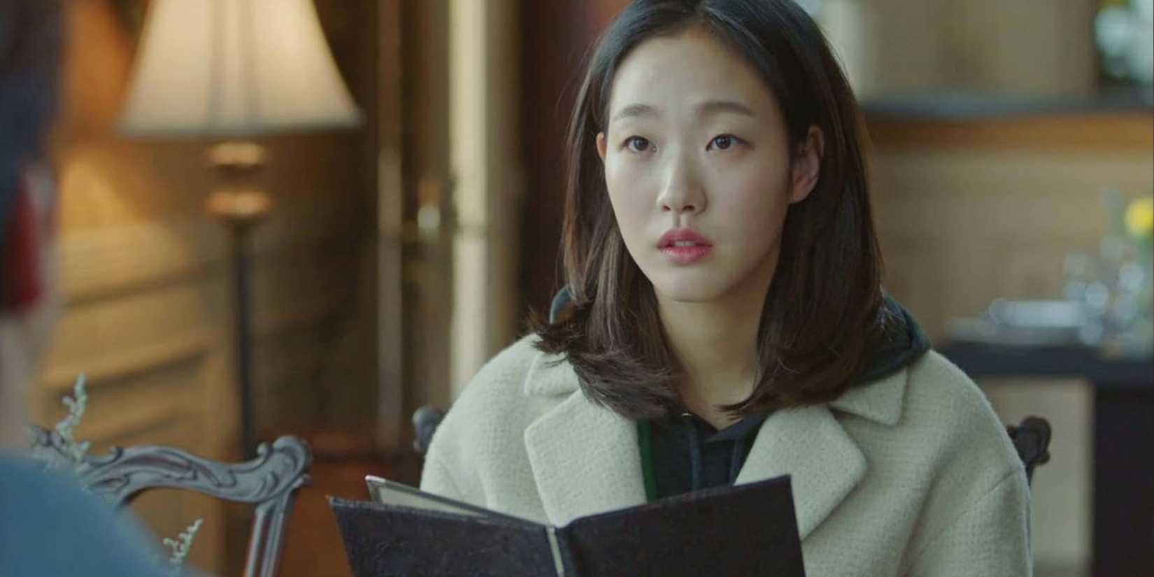 Kim Go-eun in Goblin holding a book.