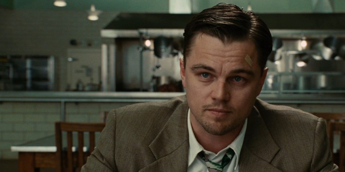 Leonardo DiCaprio as a US Marshal sitting at a table looking intently in 'Shutter Island'.