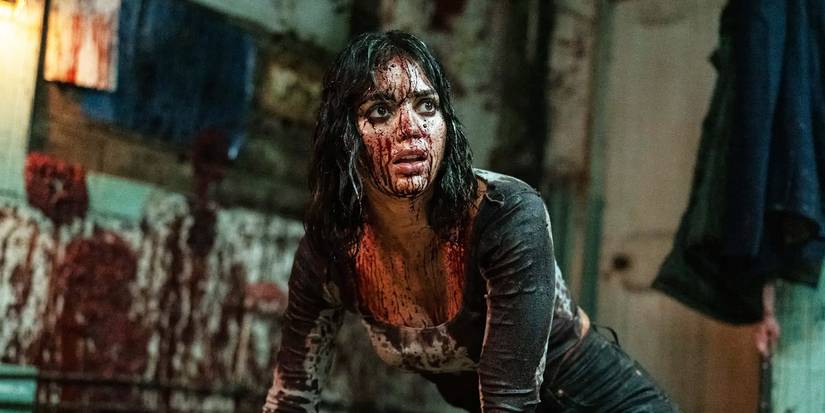 Melissa Barrera on the floor covered in blood looking shocked in Abigail