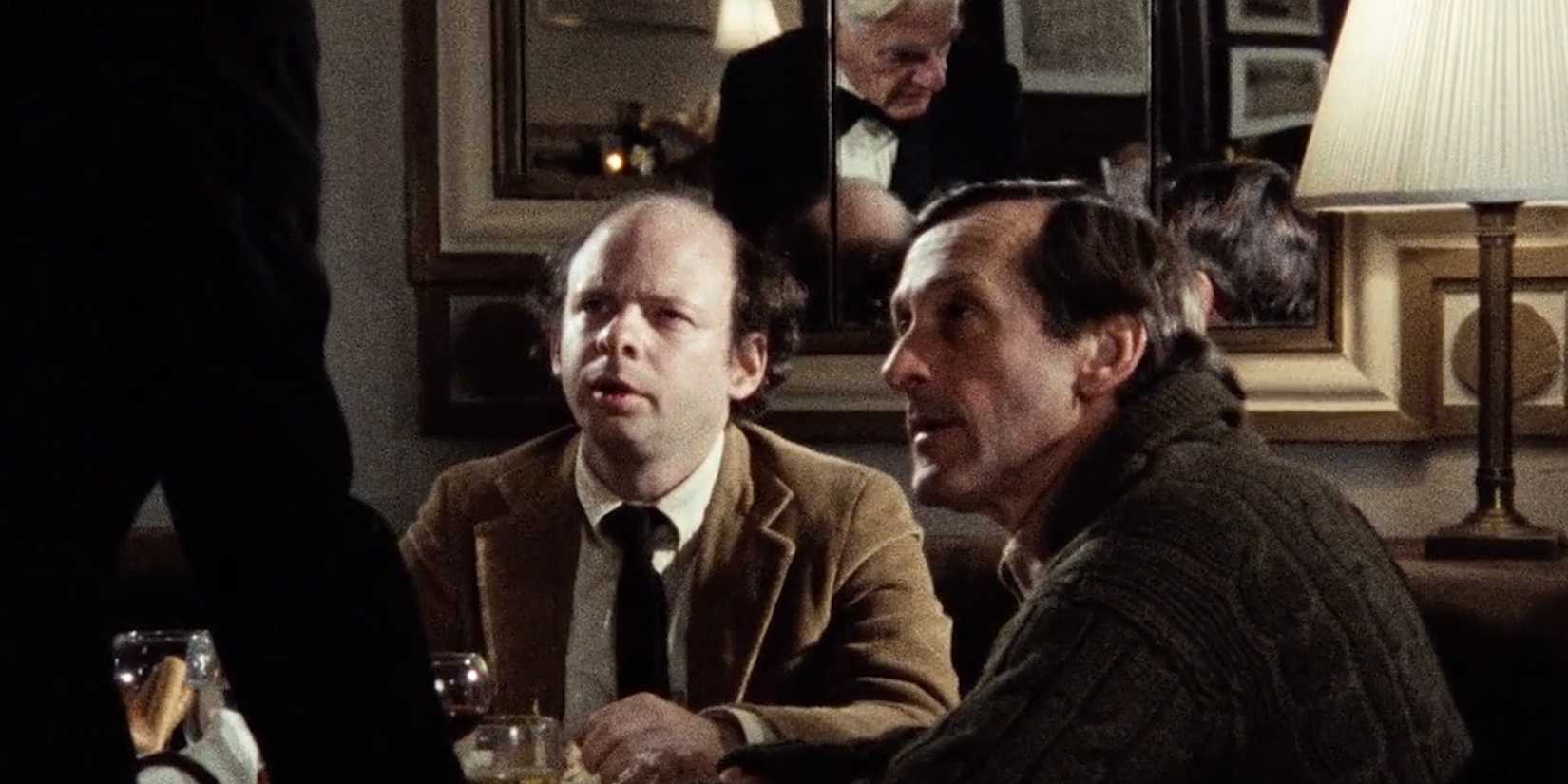 Wally and Andre looking up at a waiter with confused expresisons in My Dinner With Andre