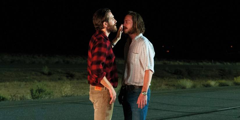 Jake Gyllenhaal and Aaron Taylor-Johnson squaring off roadside at night in Nocturnal Animals 