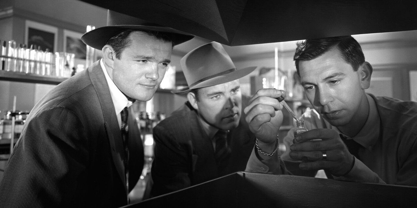 Two detectives and a forensics expert studying evidence