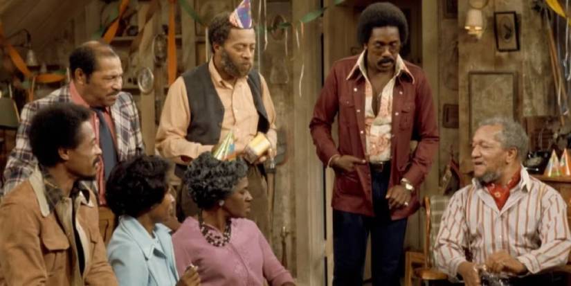 The cast of Sanford and Son talking at a birthday party