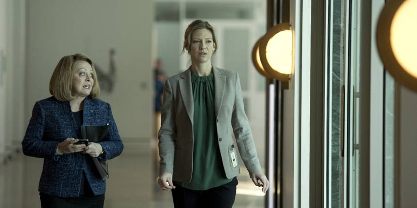 Anna Torv dan Jacki Weaver sebagai Harriet Dunkley dan Catriona Bailey, berjalan menyusuri lorong di Secret City.