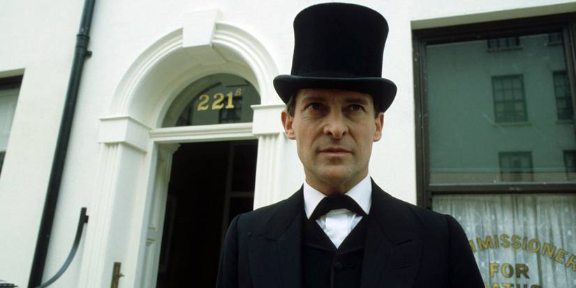 Sherlock Holmes (Jeremy Brett) stands out the front of 221B Baker Street wearing a tuxedo and a tophat.