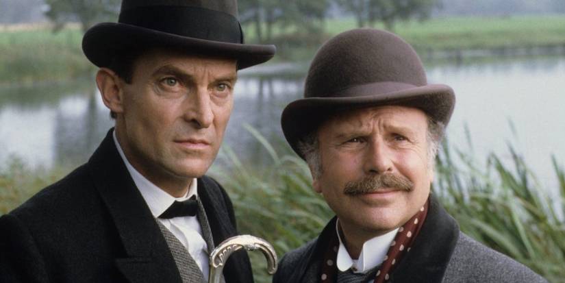 Sherlock Holmes (Jeremy Brett) and John Watson (Edward Hardwicke) stand by a lake in Sherlock Homes series