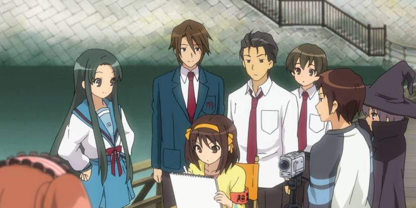 Siswa berkumpul di sekitar seseorang yang menulis di selembar kertas di melankolis Haruhi Suzumiya.