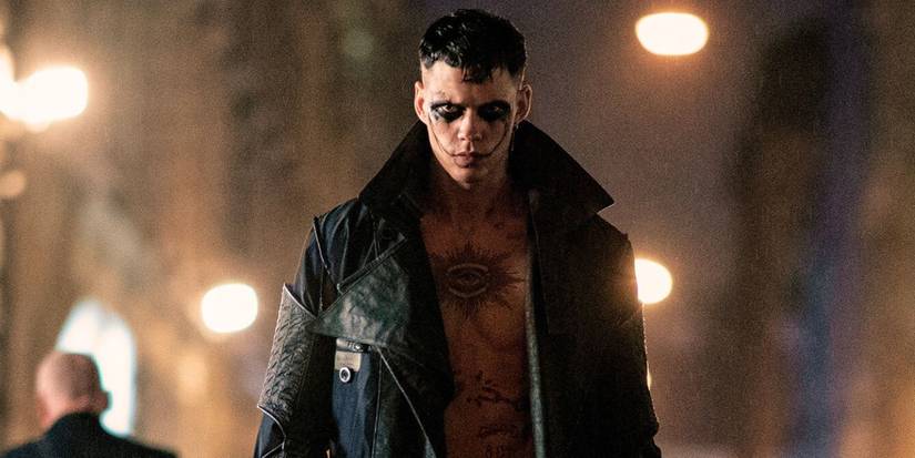 Bill Skarsgard as Eric Draven in a jacket with no shirt on and with chest tattoos in the remake of The Crow.