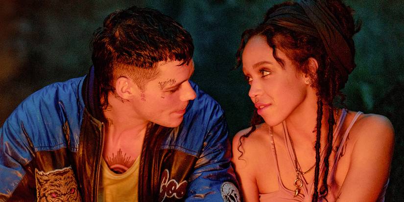Bill Skarsgard and FKA Twigs looking into each others eyes by a campfire in The Crow