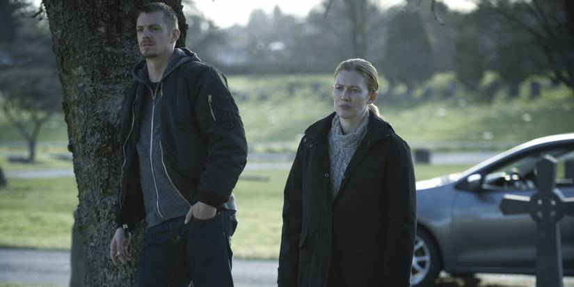 Homicide detectives Stephen Holder (Joel Kinnaman) and Sarah Linden (Mireille Enos) stand in a cemetery.