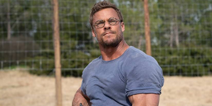 Alan Ritchson, wearing glasses, looks offscreen in The Ministry of Ungentlemanly Warfare