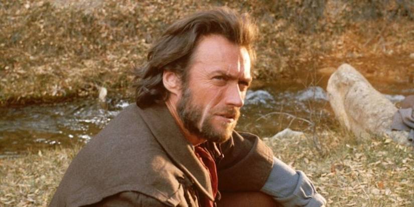 Clint Eastwood as Josey Wales, looking to the distance by a stream in The Outlaw Josey Wales.