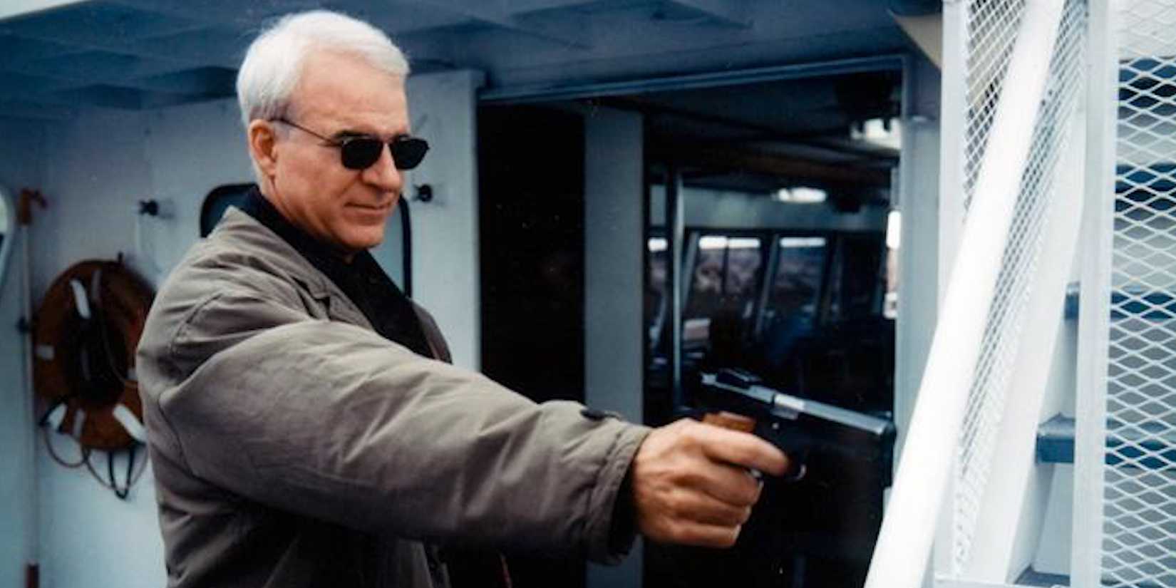 Jimmy Dell pointing a gun at someone off-camera in The Spanish Prisoner