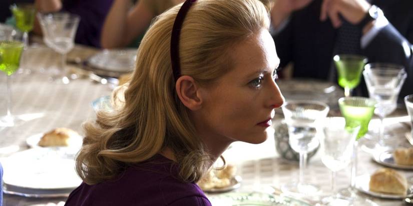 Emma Recchi at a dinner table looking to her right in I Am Love 2009