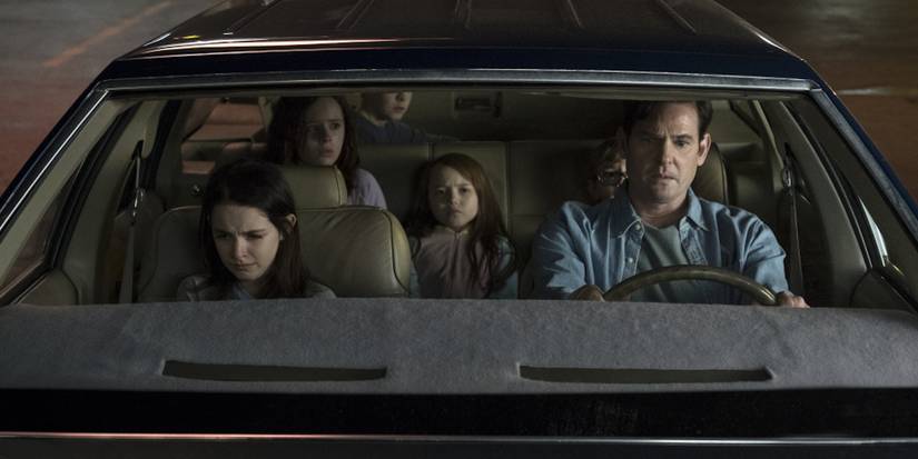 The family piles into the car, scared, in the Haunting of Hill House. 