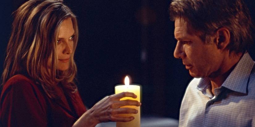 Claire (Michelle Pfeiffer) holding a candle near Norman Spencer (Harrison Ford) in What Lies Beneath