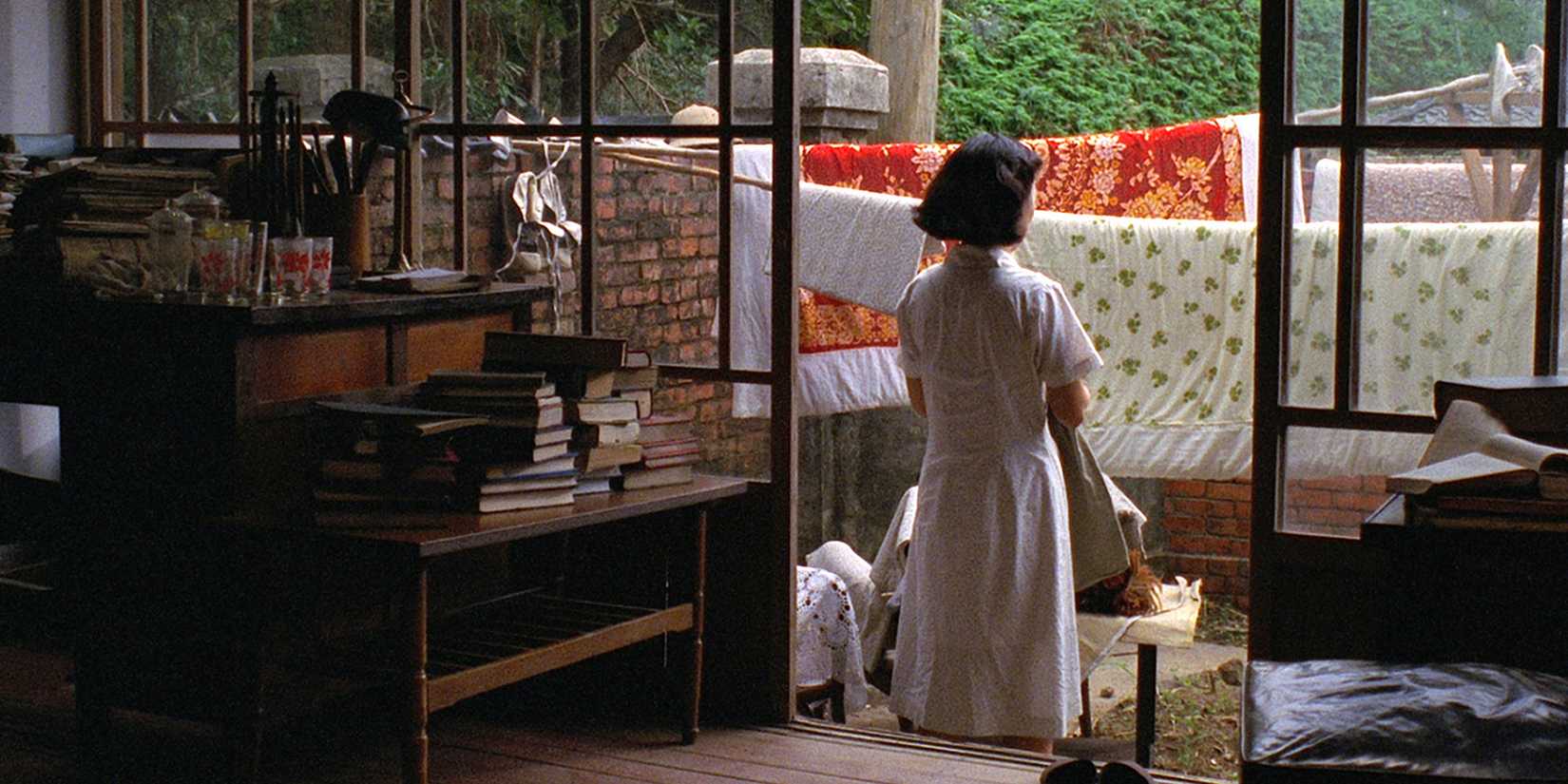 A woman in her backyard, her back turned to the camera, in 'A Brighter Summer Day'