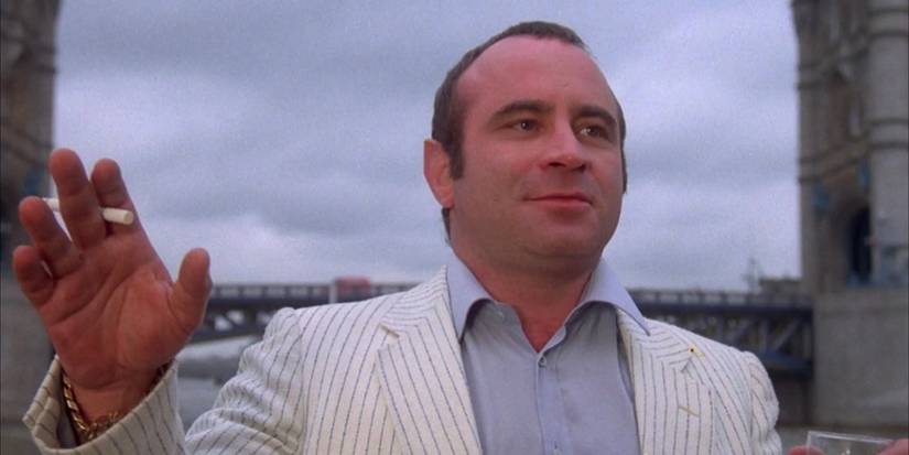 Harold Shand with his hands raised in surrender in The Long Good Friday