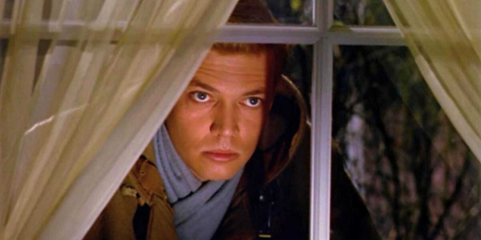 Carl Boehm as Mark Lewis peering through a window in Peeping Tom (1960).