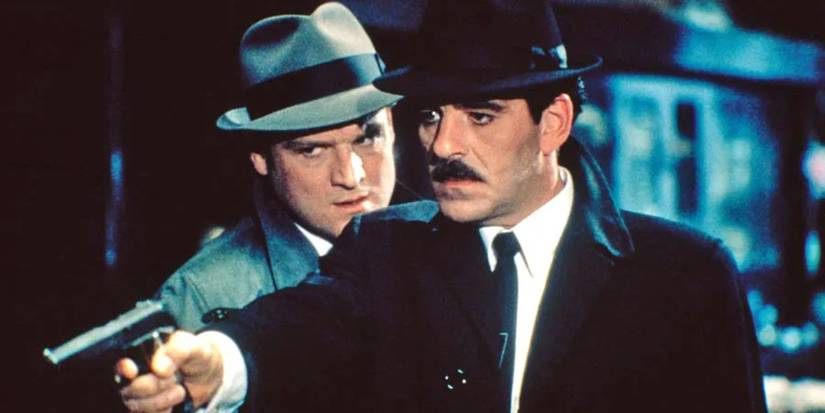 Police office Lt. Mike Torello aims a gun at someone in 'Crime Story' (1986-1988)