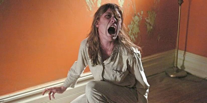 Jennifer Carpenter as Emily Rose, screaming in front of a wall covered in scratches in The Exorcism of Emily Rose