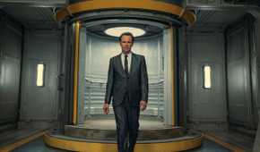 Walton Goggins as Cooper Howard walking down a vault hallway in Prime Video's Fallout