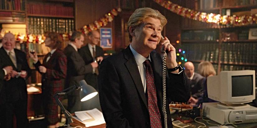 Simon Farnaby as Julian Fawcett, talking on the phone and smiling in Ghosts