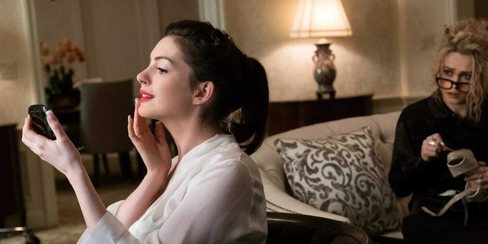 Helena Bonham Carter looking at Anne Hathaway re-touching her makeup in front of a mirror in Ocean's Eight.